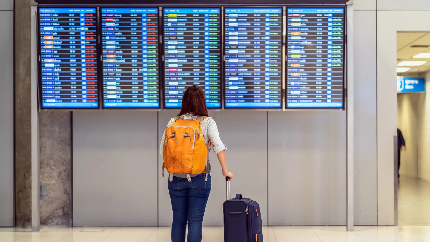 persona mirando panel de salidas aeropuerto persona mirando panel de salidas aeropuerto