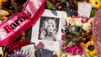 Flores y otros objetos en memoria de Dolly Parton son depositados en la entrada de su casa