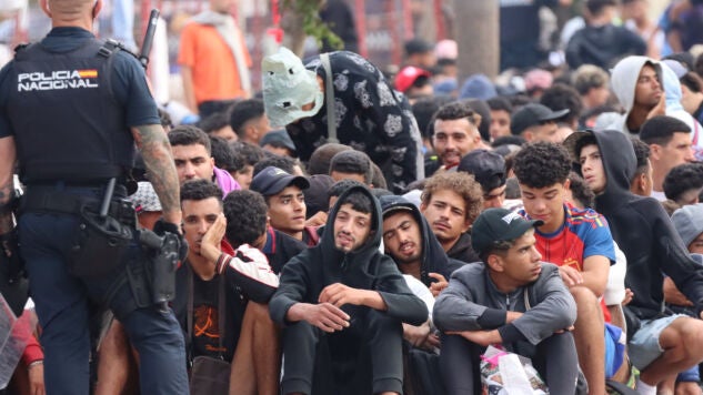 Migrantes frente a la explanada de embotellamiento de Loma Colmenar donde hace casi dos semanas, se habilit&oacute; un campamento temporal