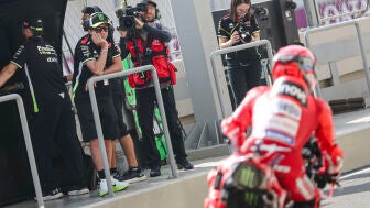 Valentino Rossi mira a Marc M&aacute;rquez saliendo del box con la Ducati