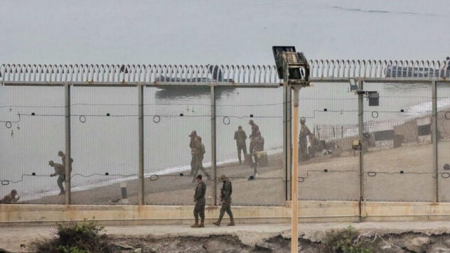 Dos soldados espa&ntilde;oles y en la parte marroqu&iacute; de la playa autoridades del pa&iacute;s vecino montan guardia en el espig&oacute;n del Tarajal 
