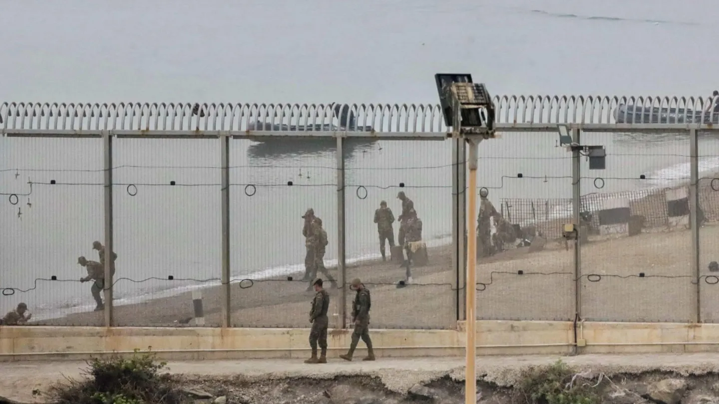 Dos soldados españoles y en la parte marroquí de la playa autoridades del país vecino montan guardia en el espigón del Tarajal Dos soldados españoles y en la parte marroquí de la playa autoridades del país vecino montan guardia en el espigón del Tarajal