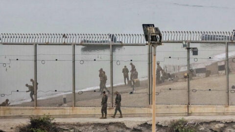 Dos soldados espa&ntilde;oles y en la parte marroqu&iacute; de la playa autoridades del pa&iacute;s vecino montan guardia en el espig&oacute;n del Tarajal 