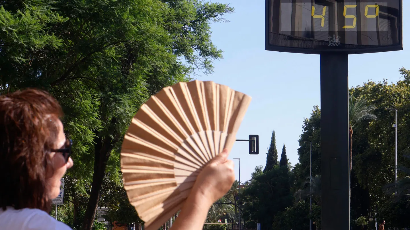 Una mujer se abanica con la temperatura marcando 45 grados Una mujer se abanica con la temperatura marcando 45 grados