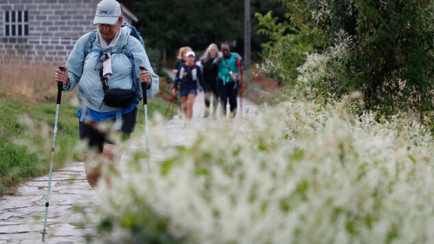 Peregrinos a su paso por la localidad lucense de Palas de Rei este martes mientras cubren el Camino de Santiago. 