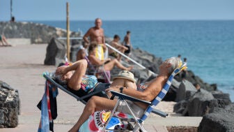 Varias personas, tomando el sol en la playa