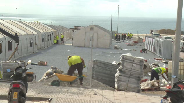 Operarios trabajan en el asentamiento para migrantes en el puerto de Ceuta