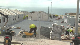 Operarios trabajan en el asentamiento para migrantes en el puerto de Ceuta