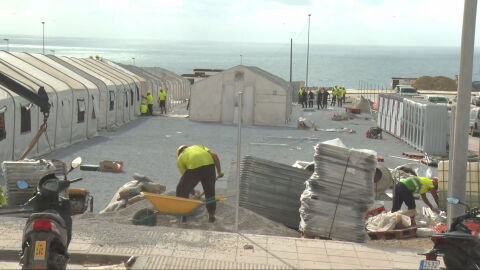 Operarios trabajan en el asentamiento para migrantes en el puerto de Ceuta