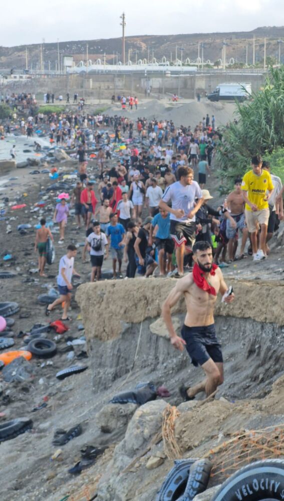 Cientos de migrantes llegan a una playa en Ceuta, ya repleta de flotadores de los anteriores. 