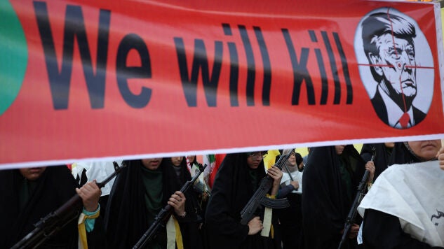 Mujeres miembros de las fuerzas de la milicia iran&iacute; portan una pancarta contra el presidente estadounidense, Donald Trump, durante una marcha militar en Teher&aacute;n.