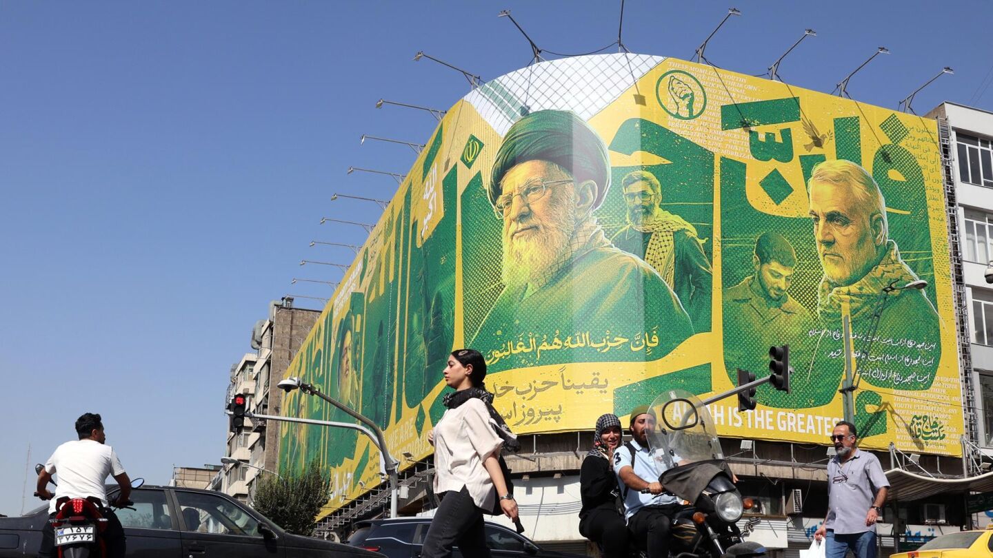 Iran&iacute;es transitan este s&aacute;bado ante una valla publicitaria en Teher&aacute;n que representa al exl&iacute;der de Hizbul&aacute;