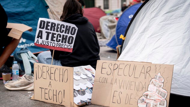 Numerosas personas con pancartas con lemas 'Derecho a techo' se concentran en tiendas de campa&ntilde;a para exigir la aprobaci&oacute;n de un decreto sobre vivienda