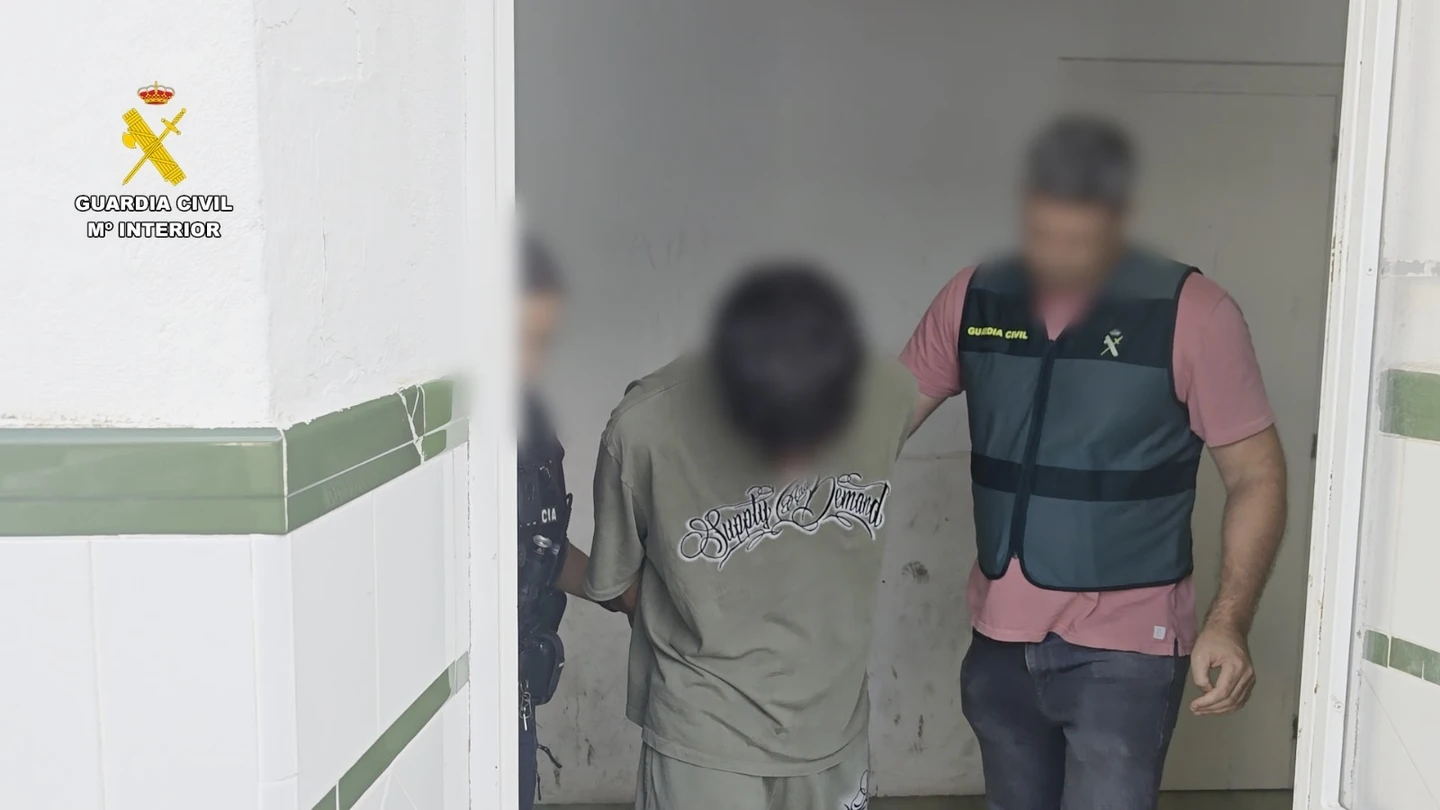 Un agente de la Guardia Civil, con uno de los detenidos. Un agente de la Guardia Civil, con uno de los detenidos.