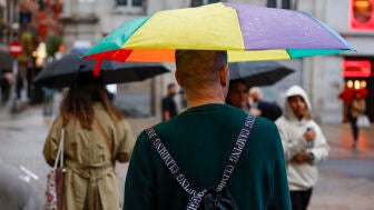 Varios viandantes se protegen de la lluvia en la Puerta del Sol de Madrid este martes.