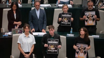 La portavoz de M&aacute;s Madrid en el Ayuntamiento, Rita Maestre (i), y los concejales de Mas Madrid muestran un cartel de Maricarmen durante un Pleno extraordinario en el Palacio de Cibeles
