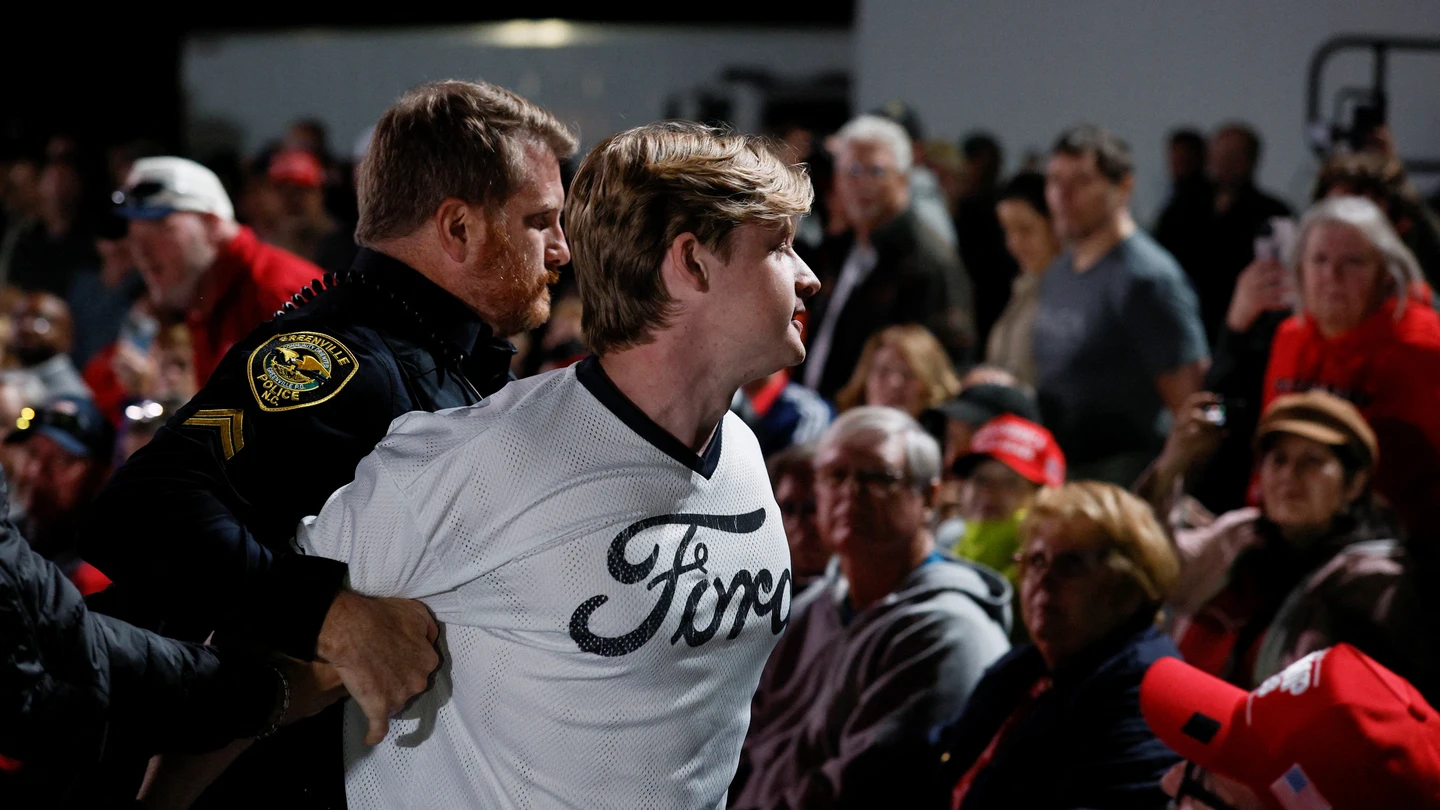 Un manifestante es retirado mientras Donald Trump habla durante un mitin en el aeropuerto de Pitt-Greenville, Carolina del Norte. Un manifestante es retirado mientras Donald Trump habla durante un mitin en el aeropuerto de Pitt-Greenville, Carolina del Norte.
