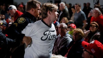 Un manifestante es retirado mientras Donald Trump habla durante un mitin en el aeropuerto de Pitt-Greenville, Carolina del Norte.