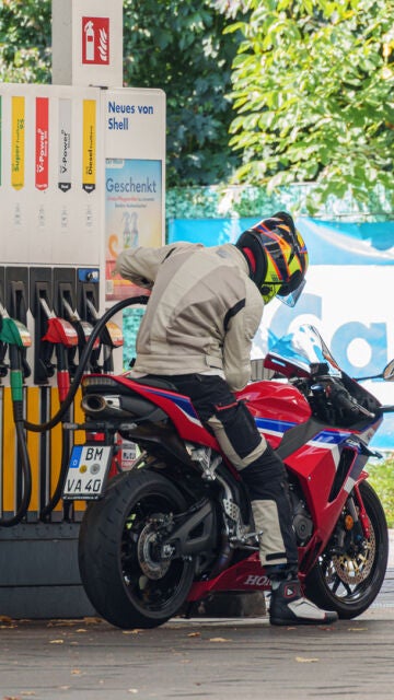 Repostando una moto sin bajarse de ella.