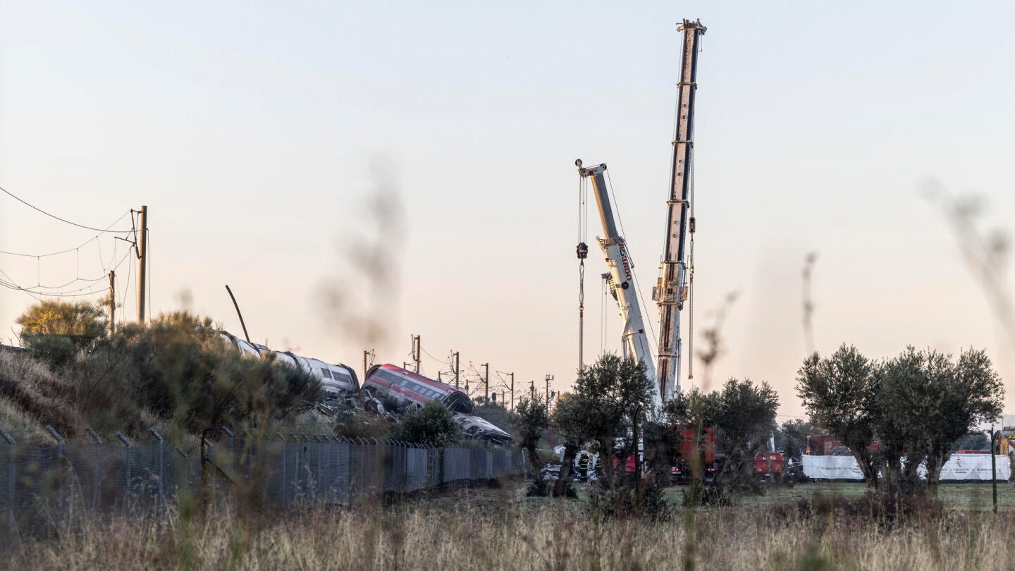 Los servicios de emergencia junto a maquinaria pesada trabajan en el lugar del accidente ferroviario un d&iacute;a despu&eacute;s del suceso